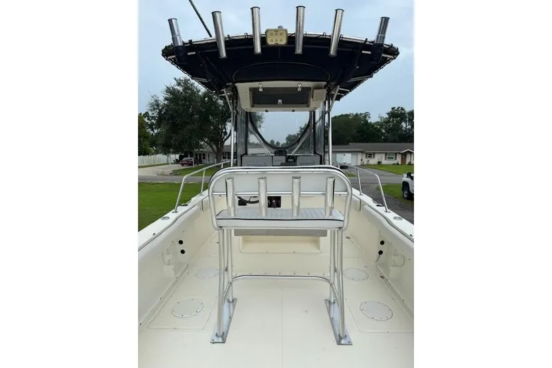 Slide: The Image of 1997 Sea Cat 255 boat interior with T-top and rod holders, parked in residential area. - 5