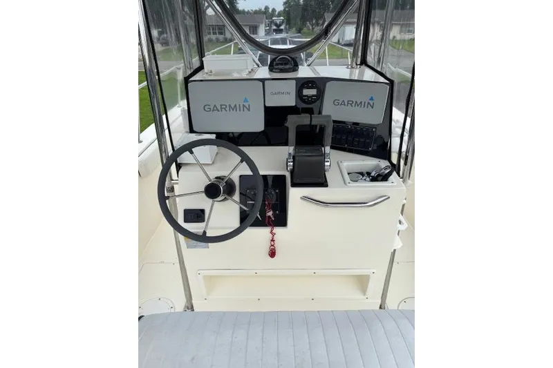 Slide: The Image of 1997 Sea Cat 255 boat dashboard with Garmin navigation system and steering wheel. - 8