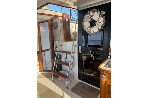 Slide: The Image of 1990 Californian 45 Motor Yacht interior with ladder, door, and decorative wreath. - 12