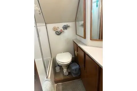 Slide: The Image of 1990 Californian 45 Motor Yacht bathroom with shower, toilet, and wooden cabinetry. - 13