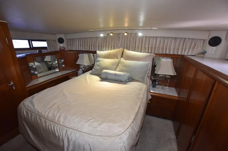 Slide: The Image of Luxurious bedroom interior of 1990 Californian 45 Motor Yacht with elegant bedding and wood accents. - 46