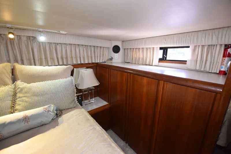Slide: The Image of Cozy bedroom interior of 1990 Californian 45 Motor Yacht with wood paneling and soft lighting. - 47