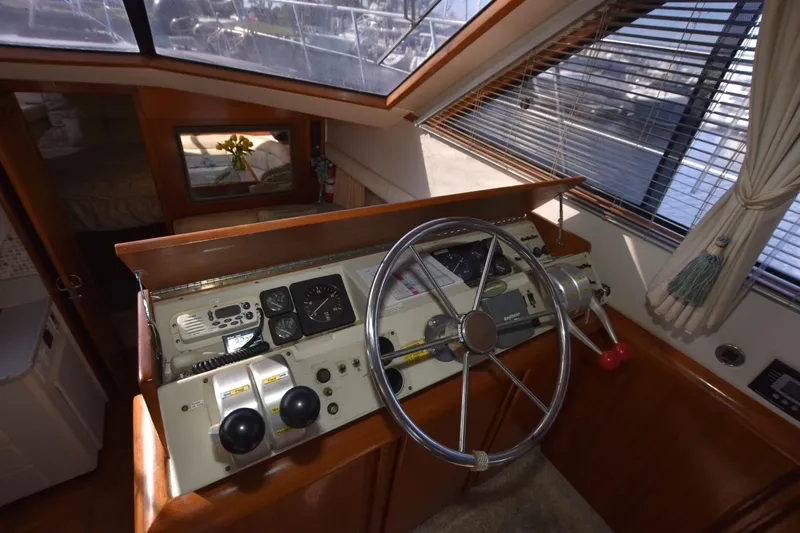 Slide: The Image of 1990 Californian 45 Motor Yacht helm with steering wheel and control panel. - 54