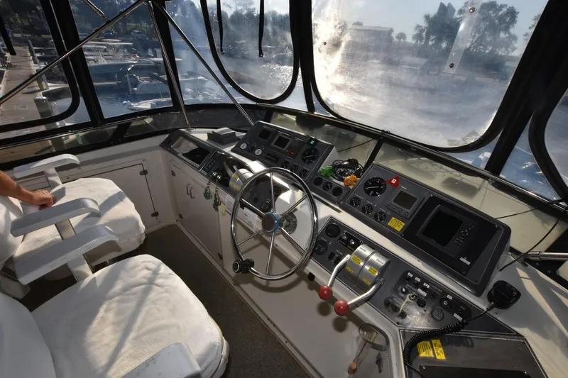 Slide: The Image of 1990 Californian 45 Motor Yacht helm with steering wheel, controls, and navigation instruments. - 60