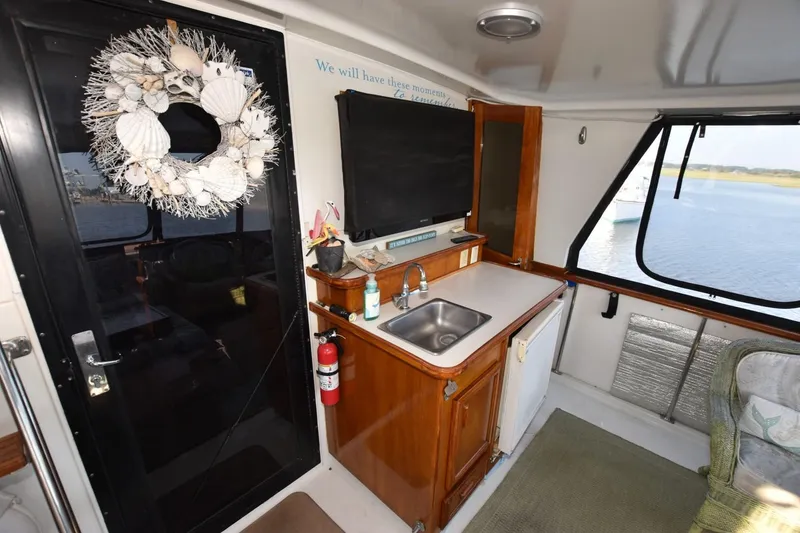 Slide: The Image of Interior of 1990 Californian 45 Motor Yacht with kitchenette and decorative seashell wreath. - 64