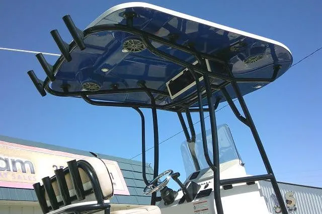 Slide: The Image of 2023 Carolina Skiff 26 Ultra Elite boat with T-top and rod holders against blue sky. - 4