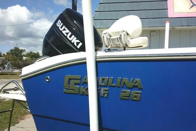 Slide: The Image of 2023 Carolina Skiff 26 Ultra Elite boat with Suzuki engine, blue hull, outdoor setting. - 5