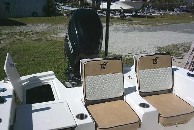 Slide: The Image of 2023 Carolina Skiff 26 Ultra Elite boat interior with cushioned seats and outboard motor. - 54