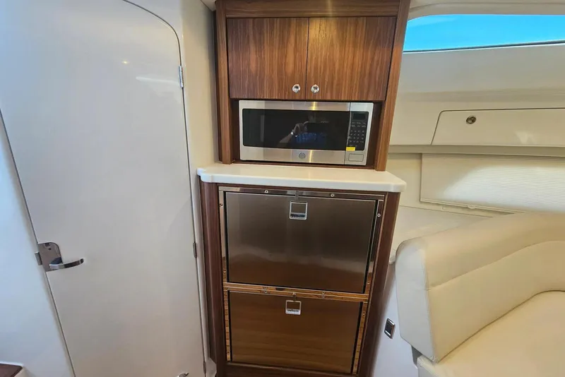 Slide: The Image of 2026 Intrepid 438 Evolution yacht interior with microwave and storage cabinets. - 12