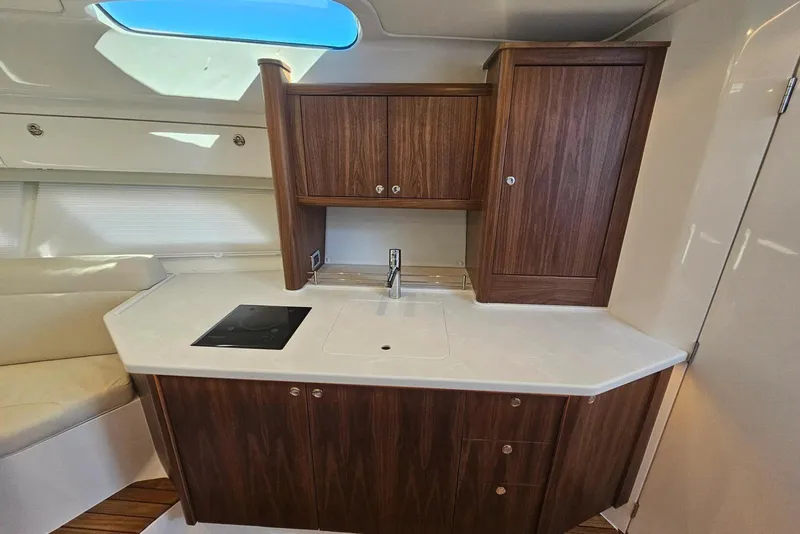 Slide: The Image of Modern kitchen area in 2026 Intrepid 438 Evolution yacht with wood cabinets and sleek countertop. - 13