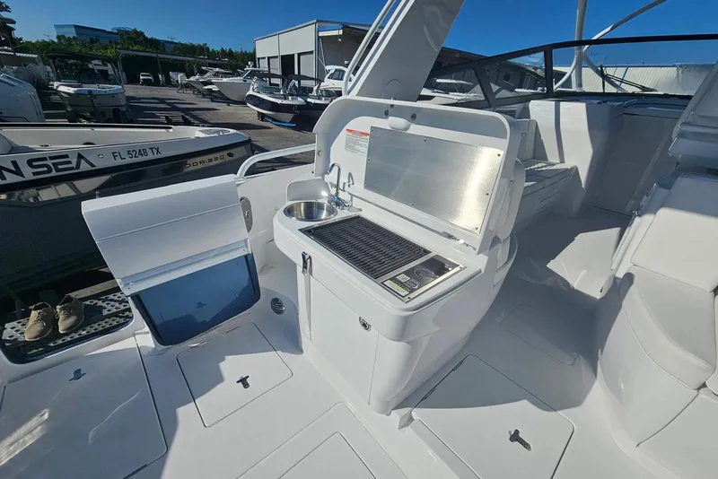 Slide: The Image of 2026 Intrepid 438 Evolution yacht with outdoor kitchen and sink in a marina setting. - 3