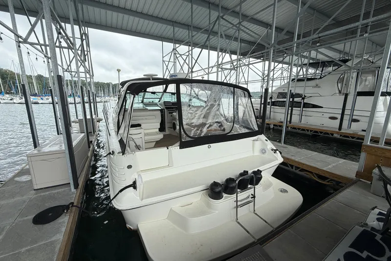 Slide: The Image of 1997 Sea Ray 400 Express Cruiser docked in a marina under a covered structure. - 11