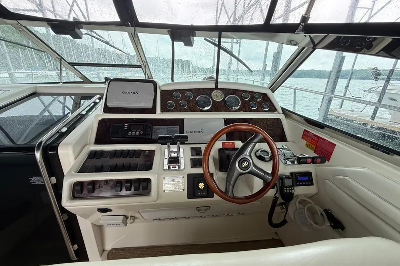 Slide: The Image of 1997 Sea Ray 400 Express Cruiser helm with Garmin navigation, steering wheel, and control panel. - 13