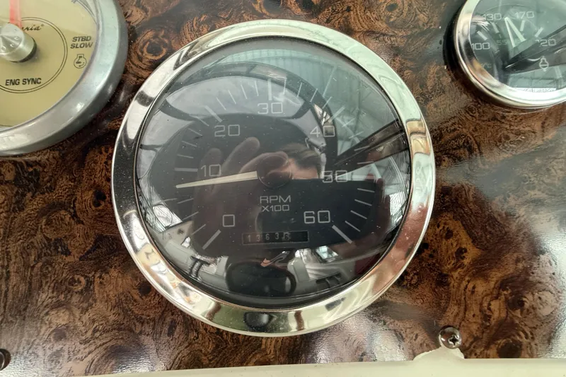 Slide: The Image of 1997 Sea Ray 400 Express Cruiser dashboard with RPM gauge and wood finish. - 18