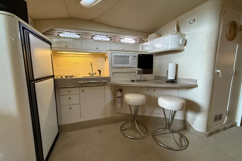 Slide: The Image of Interior of 1997 Sea Ray 400 Express Cruiser with kitchen and seating area. - 25