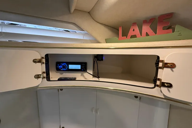 Slide: The Image of 1997 Sea Ray 400 Express Cruiser interior cabinet with stereo system and "LAKE" decor. - 26