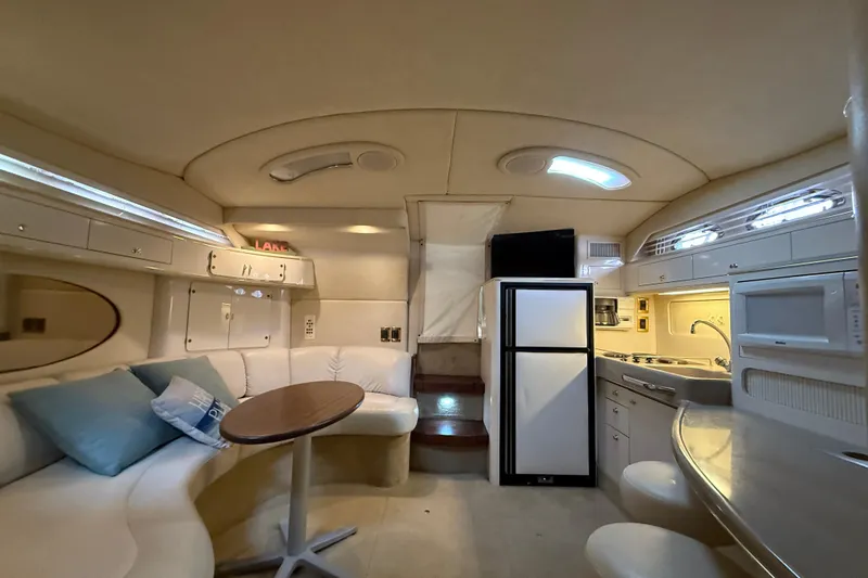 Slide: The Image of 1997 Sea Ray 400 Express Cruiser interior with kitchen, seating, and modern amenities. - 29