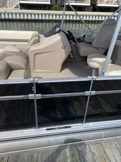 Slide: The Image of 2022 Avalon Catalina Entertainer 24' boat interior with beige seating and steering console. - 19