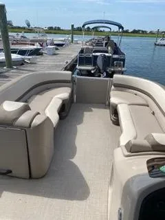 Slide: The Image of 2022 Avalon Catalina Entertainer 24' pontoon boat docked, featuring spacious seating and elegant design. - 22