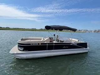 Slide: The Image of 2022 Avalon Catalina Entertainer 24' pontoon boat on calm water, blue sky background. - 25
