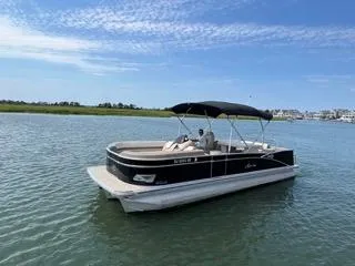 Slide: The Image of 2022 Avalon Catalina Entertainer 24' pontoon boat on calm water under blue sky. - 26