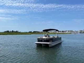 Slide: The Image of 2022 Avalon Catalina Entertainer 24' pontoon boat on a serene lake. - 27