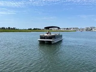 Slide: The Image of 2022 Avalon Catalina Entertainer 24' pontoon boat on a calm lake. - 28