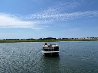 Slide: The Image of 2022 Avalon Catalina Entertainer 24' pontoon boat on a serene lake under a blue sky. - 29