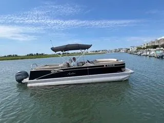 Slide: The Image of 2022 Avalon Catalina Entertainer 24' pontoon boat on calm water, clear sky. - 30
