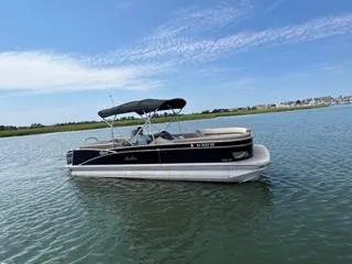Slide: The Image of 2022 Avalon Catalina Entertainer 24' pontoon boat on calm water under blue sky. - 31