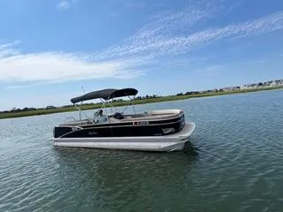 Slide: The Image of 2022 Avalon Catalina Entertainer 24' pontoon boat on calm water under blue sky. - 32