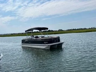 Slide: The Image of 2022 Avalon Catalina Entertainer 24' pontoon boat on calm water. - 33