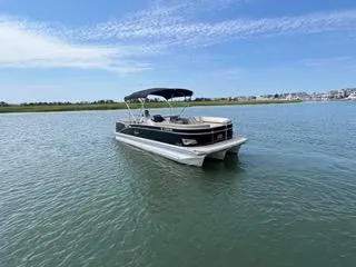 Slide: The Image of 2022 Avalon Catalina Entertainer 24' pontoon boat on calm water under blue sky. - 34