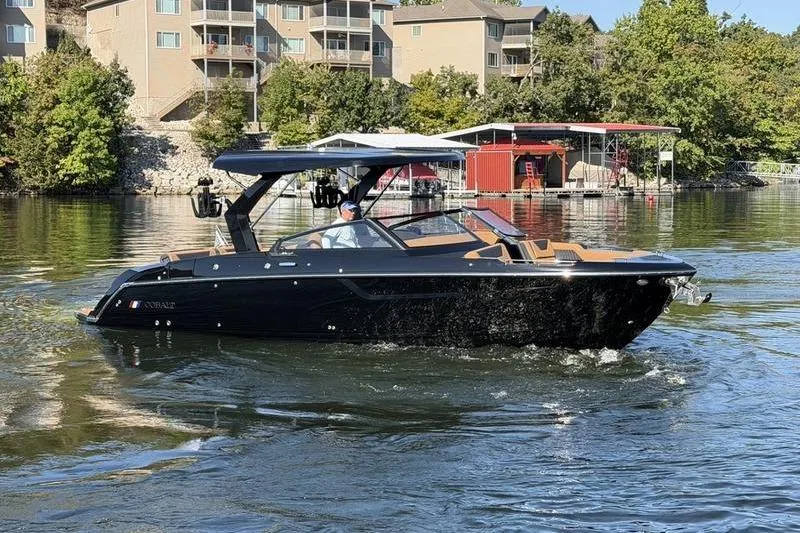 The Image of 2026 Cobalt R31 Surf boat cruising on a lake near waterfront homes. - 1