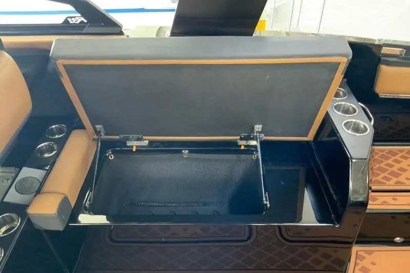 Slide: The Image of 2026 Cobalt R31 Surf boat interior with open storage compartment and cup holders. - 26
