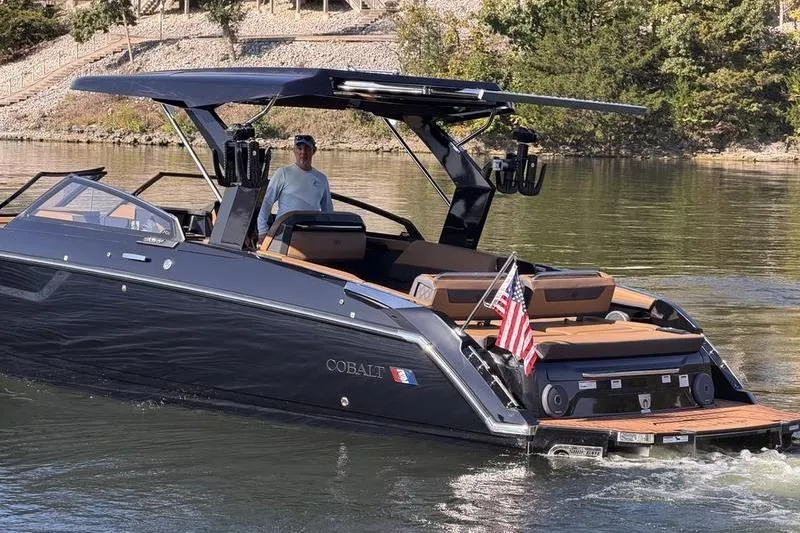 Slide: The Image of 2026 Cobalt R31 Surf boat cruising on a lake with a person onboard. - 3