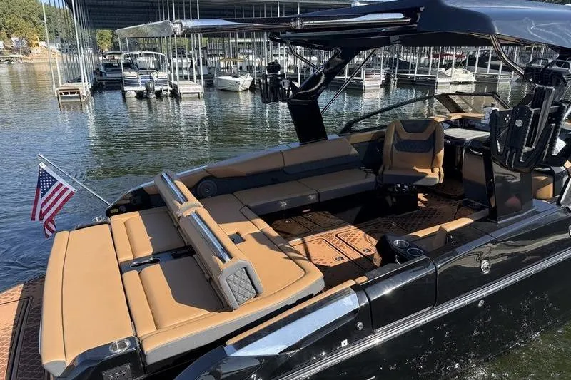 Slide: The Image of 2026 Cobalt R31 Surf boat with tan seating, docked at a marina. - 4