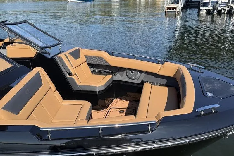 Slide: The Image of 2026 Cobalt R31 Surf boat with luxurious tan seating on a calm lake. - 5