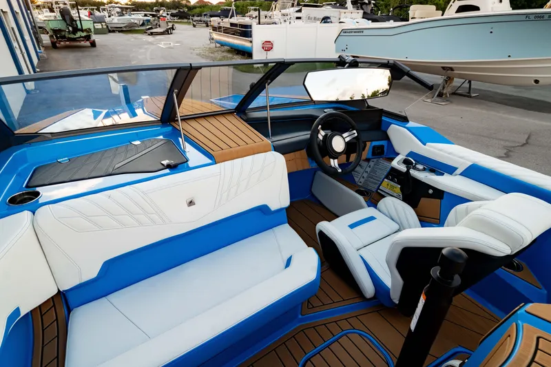 Slide: The Image of 2026 Nautique Ski Nautique boat interior with blue and white seating, modern dashboard, and steering wheel. - 1