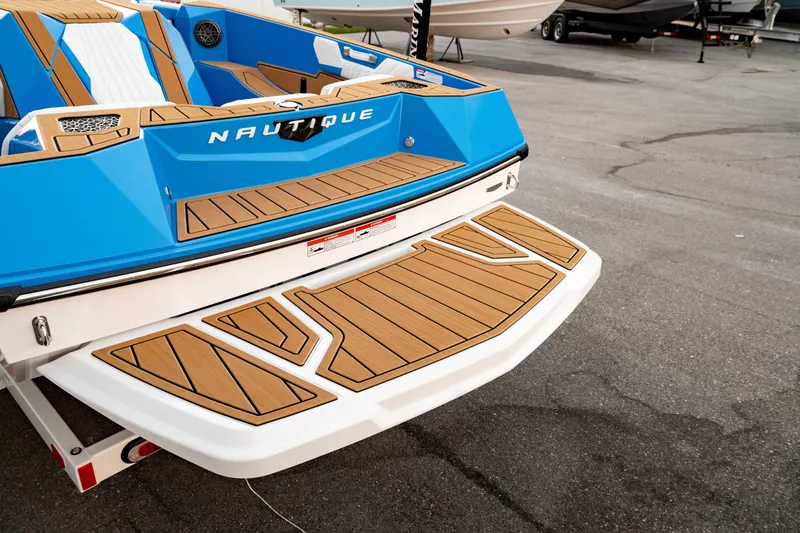 Slide: The Image of 2026 Nautique Ski Nautique boat with blue and wood accents, rear view. - 4