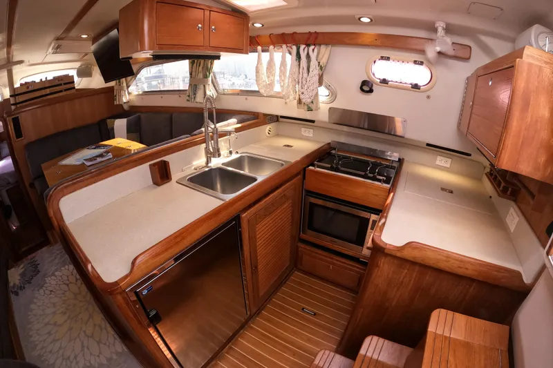 Slide: The Image of Luxurious 2005 Catalina Morgan 440 yacht interior with modern kitchen and wooden cabinetry. - 21