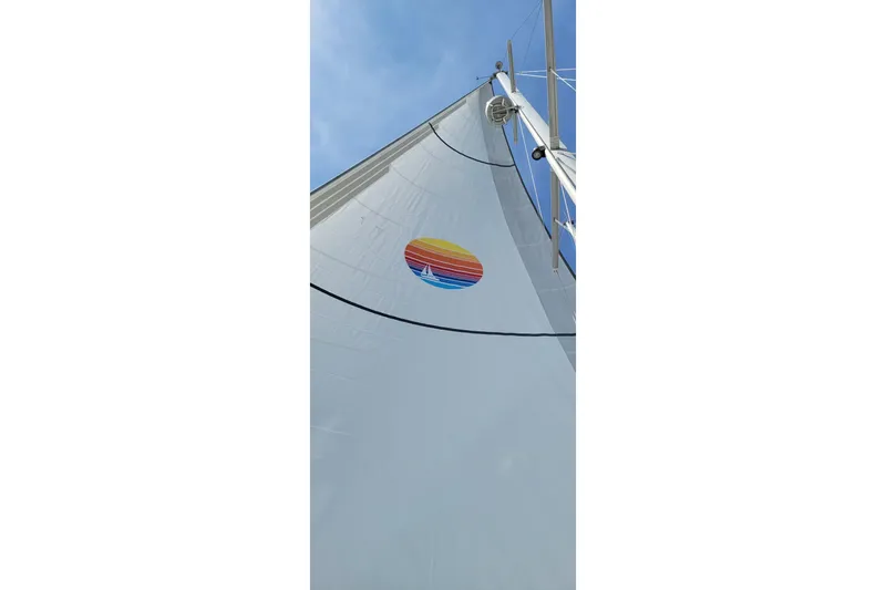 Slide: The Image of Sail of 2005 Catalina Morgan 440 yacht with colorful logo against blue sky. - 4