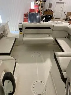 Slide: The Image of 2022 Sailfish 245DC boat interior with seating and storage in a garage setting. - 13