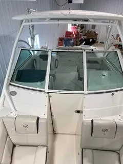 Slide: The Image of 2022 Sailfish 245DC boat interior with seating and windshield in a storage facility. - 18
