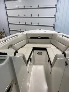 Slide: The Image of 2022 Sailfish 245DC boat interior with white cushioned seating in a garage. - 19