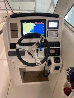 Slide: The Image of 2022 Sailfish 245DC boat dashboard with steering wheel and navigation display. - 22