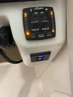 Slide: The Image of 2022 Sailfish 245DC boat control panel with illuminated trim tab controls. - 23