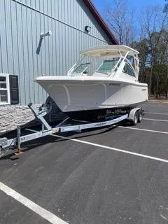 Slide: The Image of 2022 Sailfish 245DC boat on trailer, parked near a building. - 4