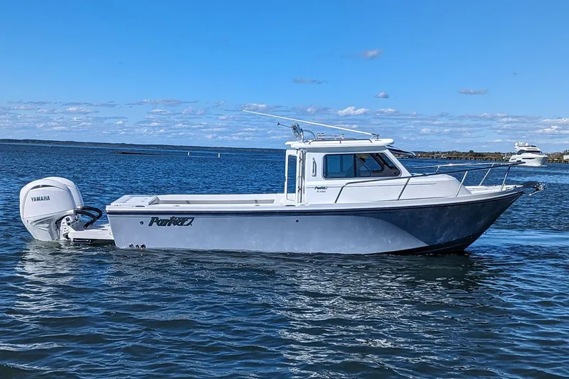 Slide: The Image of Manufacturer Provided Image: 2025 Parker 2420 Sport Cabin boat cruising on a sunny day. - 2