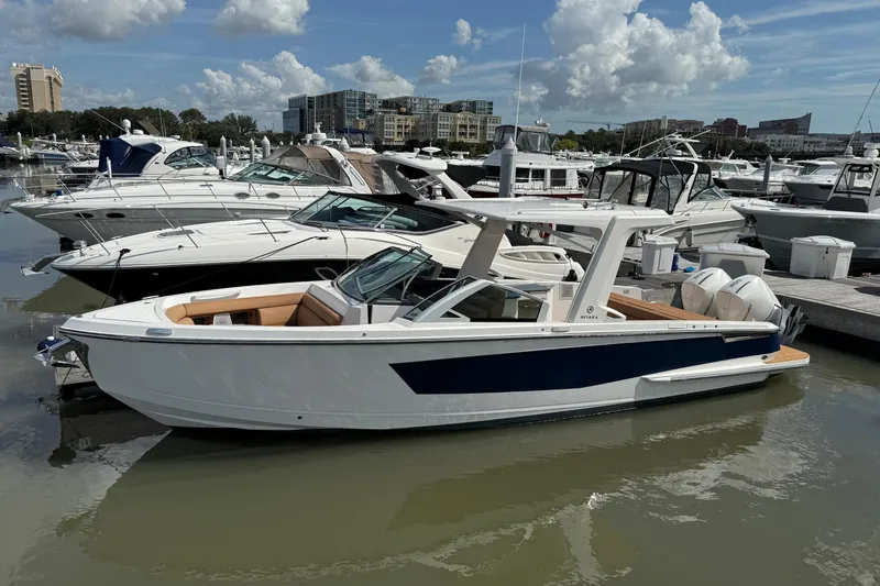 The Image of 2022 Aviara AV32 OB luxury boat docked in a marina under a partly cloudy sky. - 0
